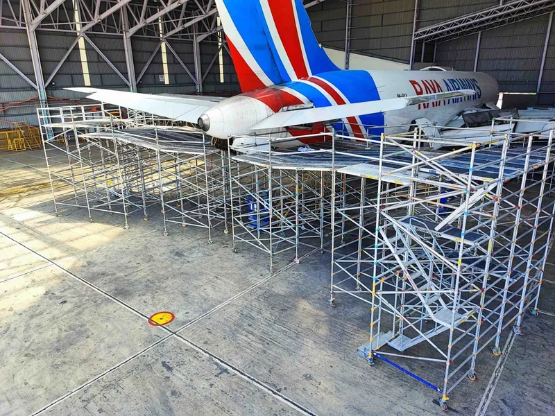 Scaffold beside a Raya Airways fuselage
