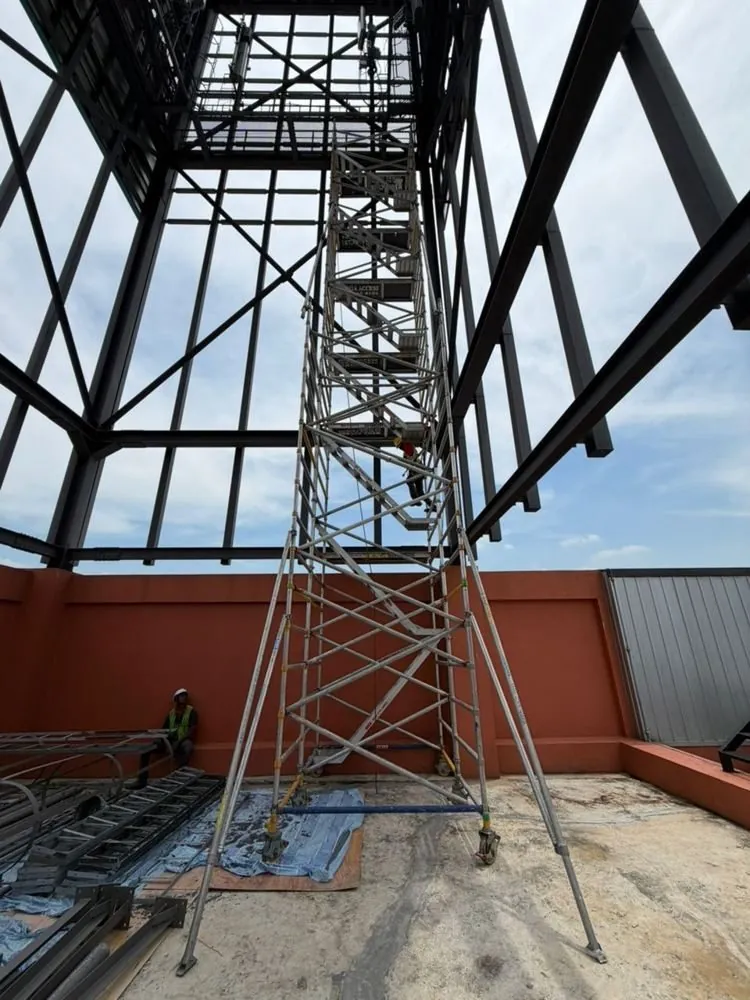 Tall aluminium tower under a mall skylight