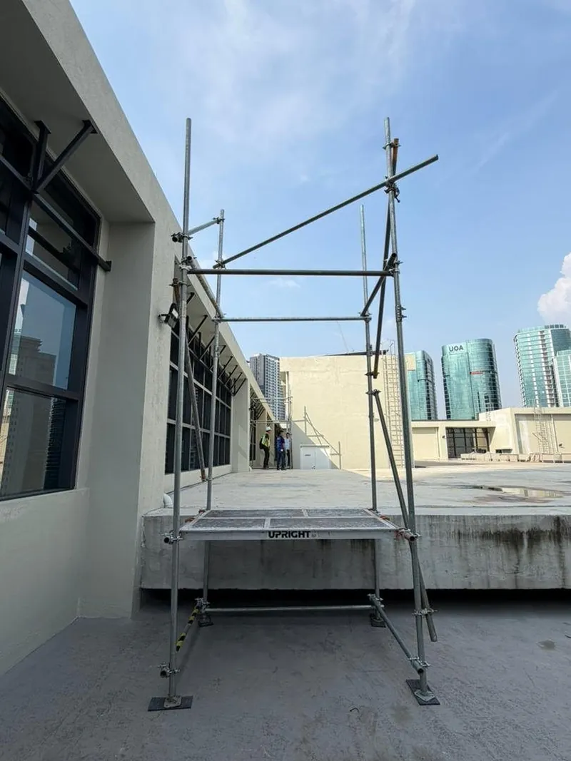 Rooftop scaffold beside glass windows